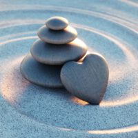 Stack,Of,Dark,Stones,With,Heart,In,Sand,Waves,-